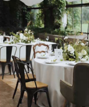 Elegant tables with floral centerpieces by large windows.